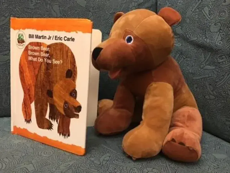 A book next to a stuffed bear