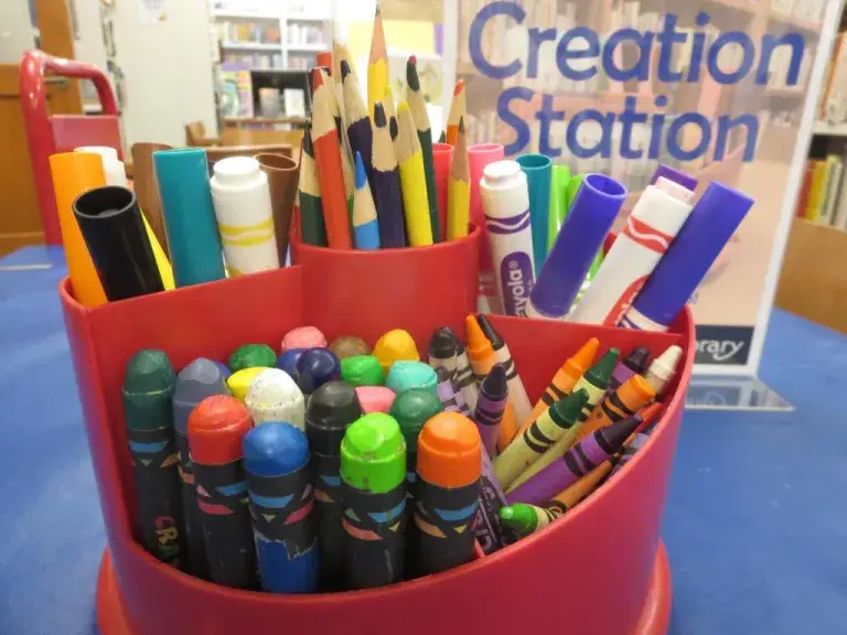 All kinds of crayons and coloring supplies on a table