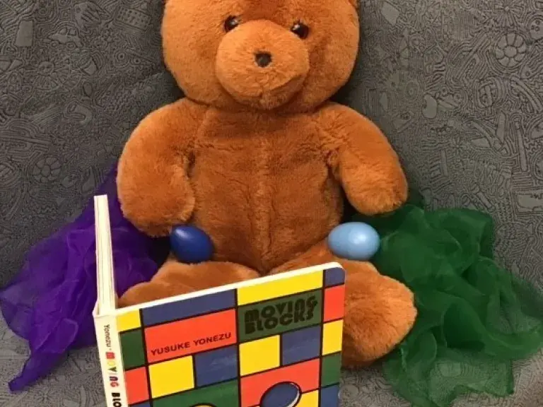 A teddy bear with a book welcomes you to Wiggles &amp; Giggles